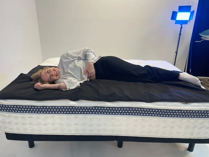 Our lightweight tester evaluating the pressure relief of The WinkBed luxury firm model