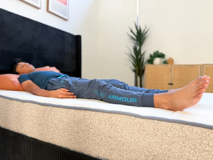 A young tester rests on his back on the Birch Kids mattress