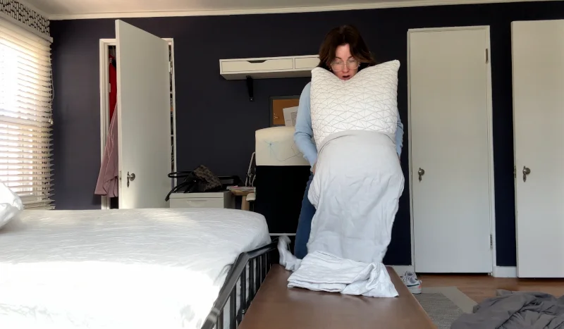Our tester crams a pillow into a pillowcase from the Parachute Home Linen Sheet Set
