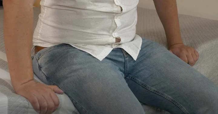 A man sits near the edge of the Leesa Original Hybrid