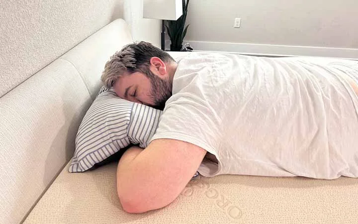 A man rests on his stomach on top of the Plushbeds Latex topper. A man rests on his stomach on top of the Plushbeds Latex topper.