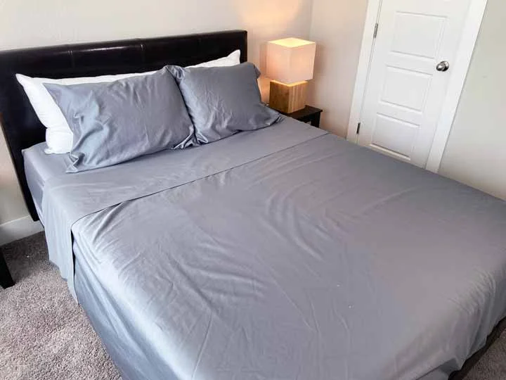 Pizuna Sheet Set An image of the Pizuna Sheets dressed on a bed to show that it includes a top sheet, a fitted sheet, and two pillow cases.