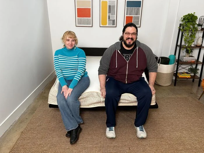 two testers sitting at the foot of the birch natural mattress