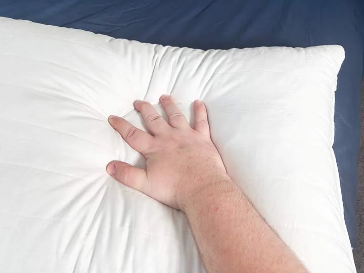 A hand presses into the Marlow pillow. A hand presses into the Marlow pillow.