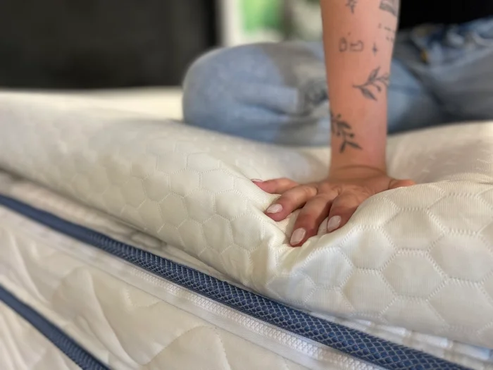 Our tester feeling the edge of a Helix GlacioTex Premium Mattress Topper