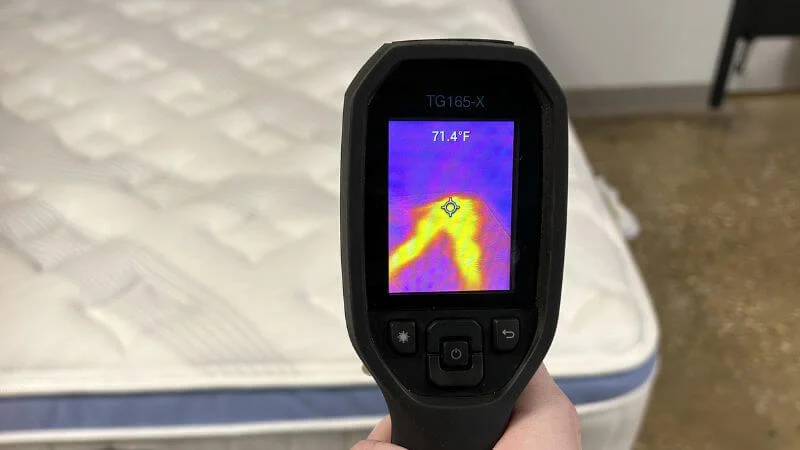 Our tester examining the cooling capabilities of the Bear Star Hybrid mattress with a thermal gun