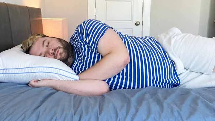 Henrie Pillow Side Sleeping A man sleeps on his side with the Henrie Pillow