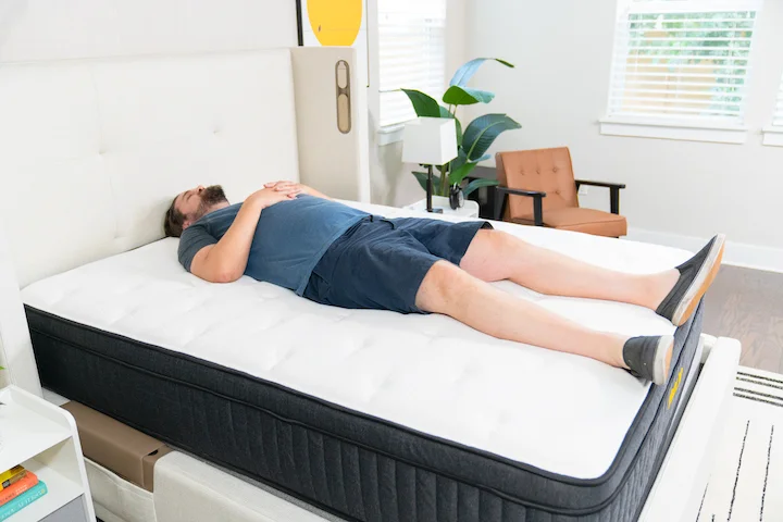 a man sleeps on his back on the Titan Plus mattress