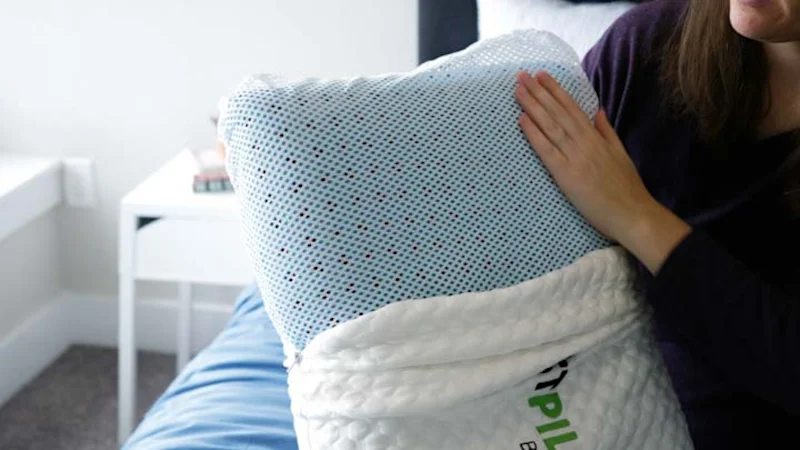 A person holding a perforated cooling pillow