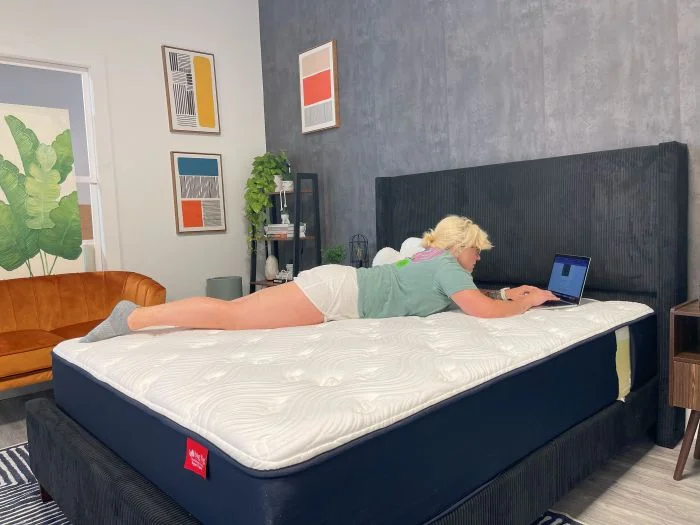 A woman lays on her stomach on the Big Fig Classic mattress