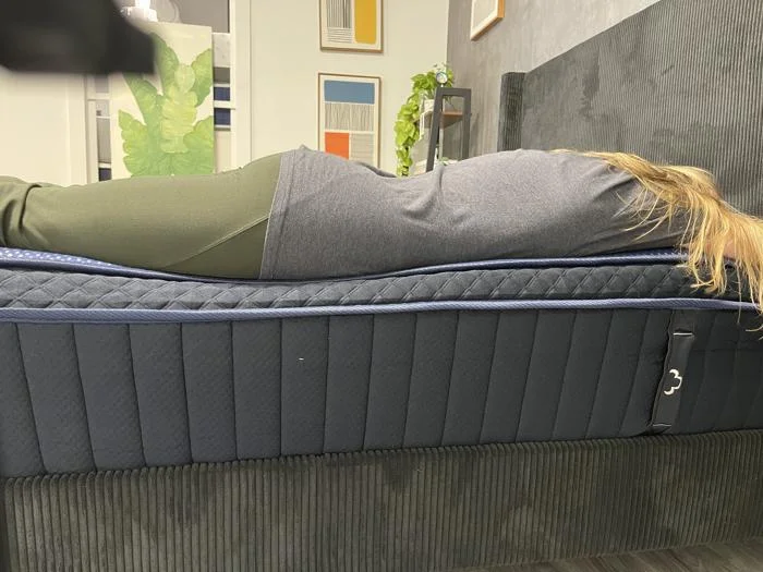 Our tester does a stomach-sleeping full body edge support test on the DreamCloud Luxe Hybrid