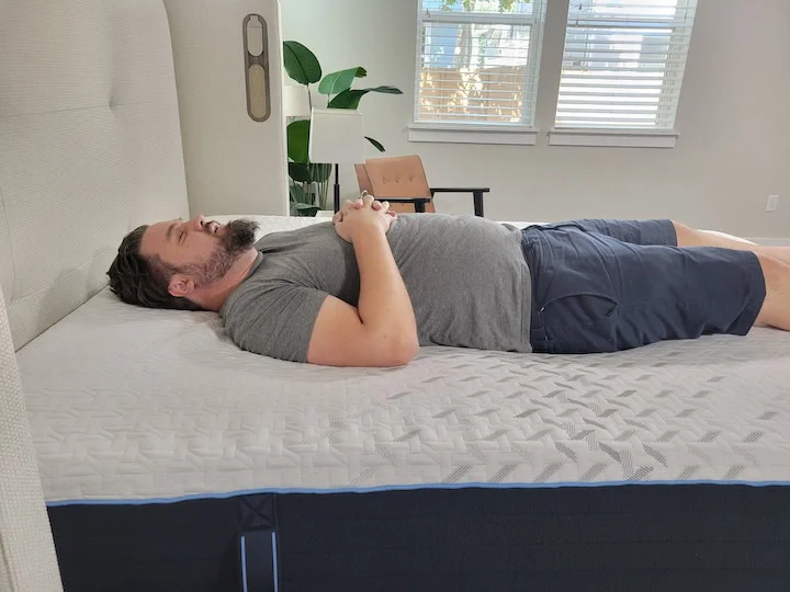 A man sleeps on his back on the Nectar Classic Hybrid.