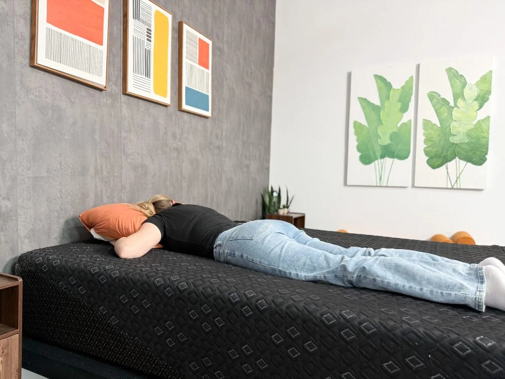 Our tester lies on her stomach on the Beautyrest Black Hybrid XCS