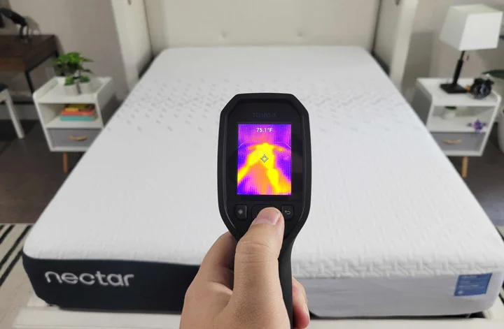 A man tests the cooling on the Nectar Classic mattress