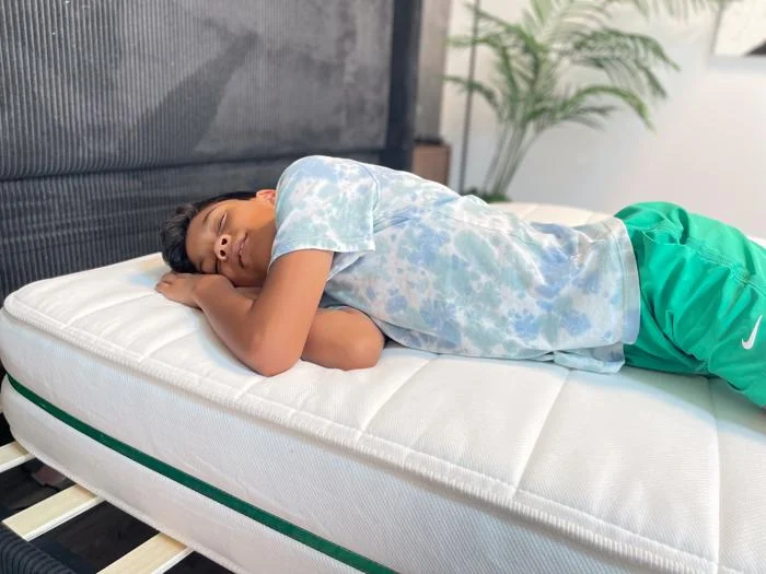 Our young tester side-sleeping on a Helix Kids Mattress 3