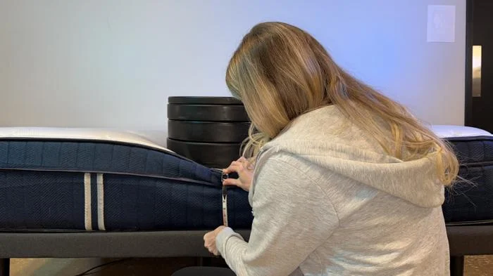 Measuring weight plates on the edge of the Silk & Snow Hybrid Mattress