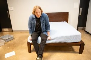 Our tester Matt Schickling sits on the edge of a Big Fig Platform Bed