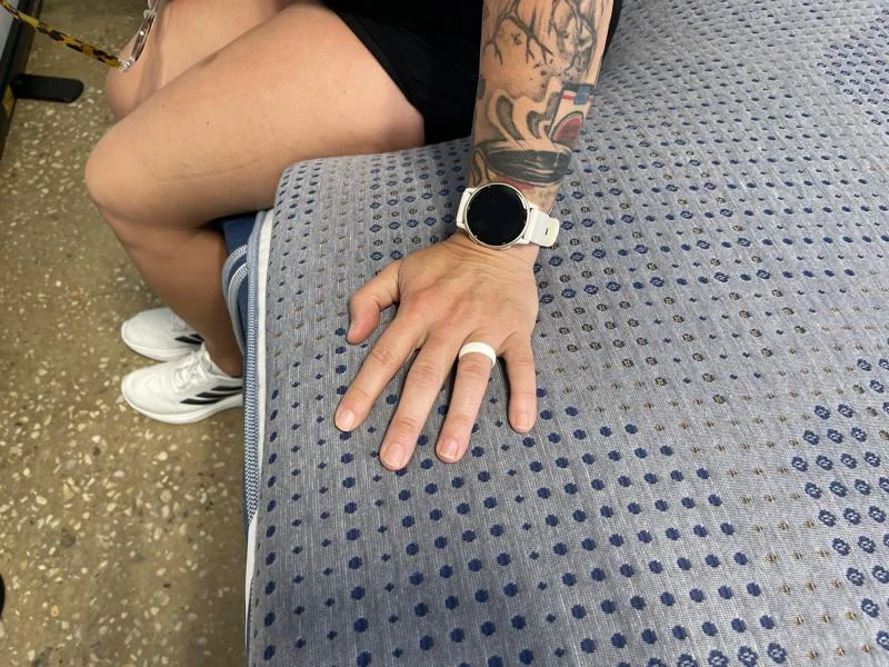 Our tester sits with her hand resting on the edge of a Brooklyn Bedding Copperflex 201 Mattress Topper