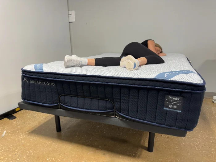 Kayla lying on her side on the DreamCloud Premier mattress