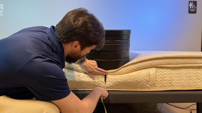 Measuring weight plates on the edge of the Saatva Latex Hybrid Mattress