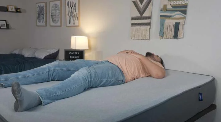 A man sleeps on his back on the Casper Select mattress A man sleeps on his back on the Casper Select mattress