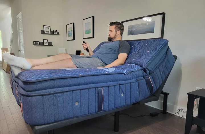 A wide shot of a man raising the head area of the Nolah adjustable base