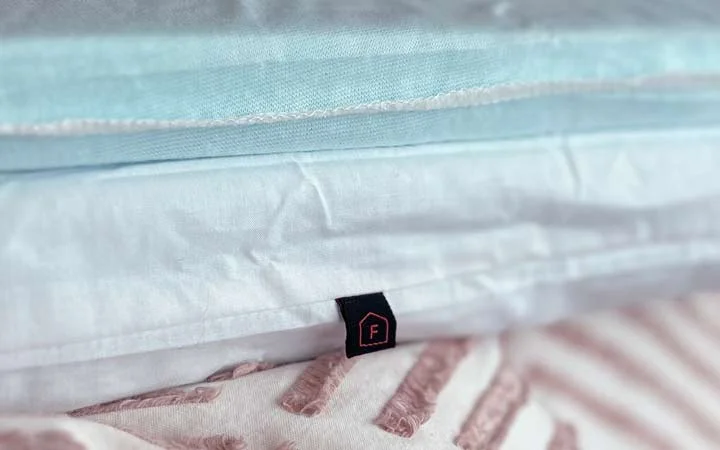 A close up image showing the label for the firm insert of the Luxome Layr pillow.