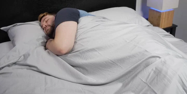 GhostBed Sheets - A man sleeps with the sheets in bed. A man sleeps with GhostBed sheets in bed