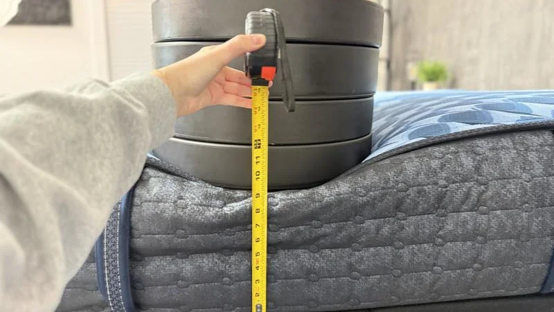 Our tester measures the sinkage from weight plates along the edge of the Serta iComfort Aspire Mattress