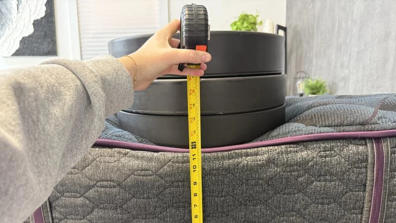 Our tester measures the sinkage from weight plates along the edge of the Beautyrest World Class Mattress