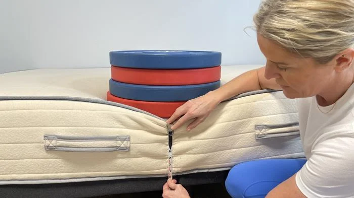 Measuring weight plates on the edge of a Nolah Natural Mattress 2