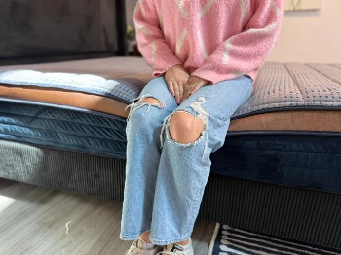 Our tester sitting on the edge of the CopperFlex Memory Foam mattress.