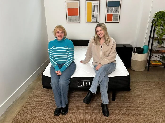 Authors Livvi DiCicco and Riley Otis on the Plank Firm mattress by Brooklyn Bedding.