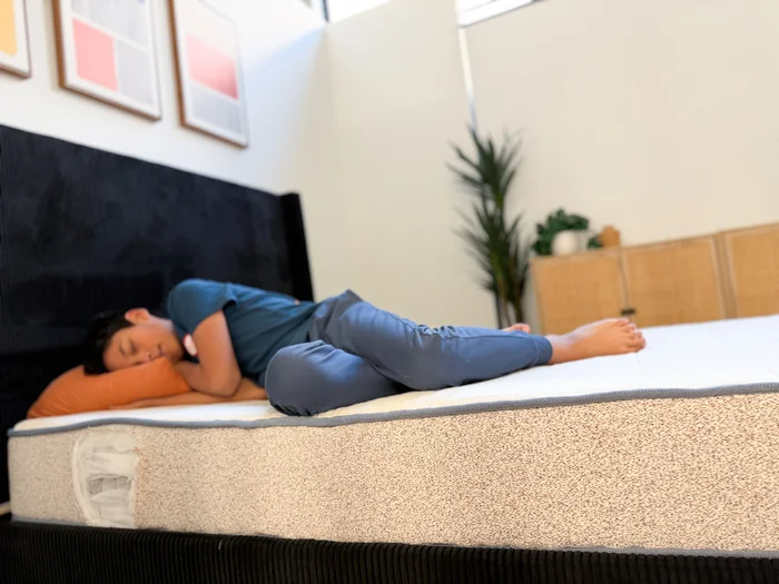 A young tester rests on his side on the Birch Kids mattress