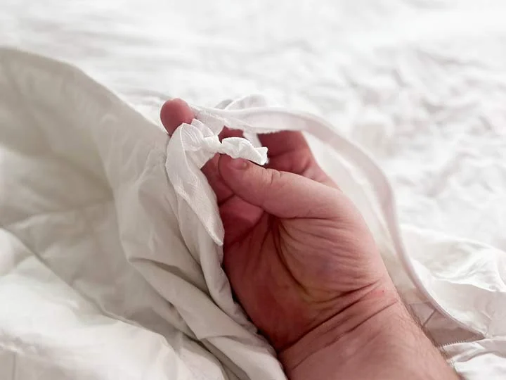 A close up image of the ties used to attach the insert to the cover of the Luxome weighted blanket.