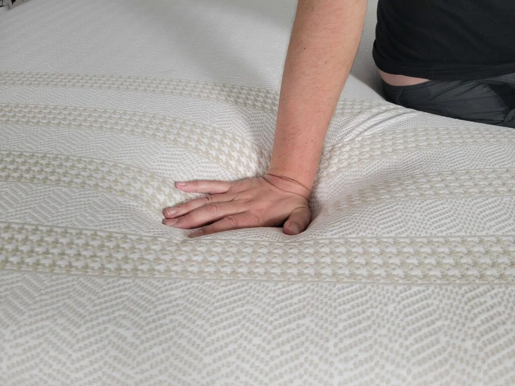 a man presses into the cover of the Leesa Reserve mattress