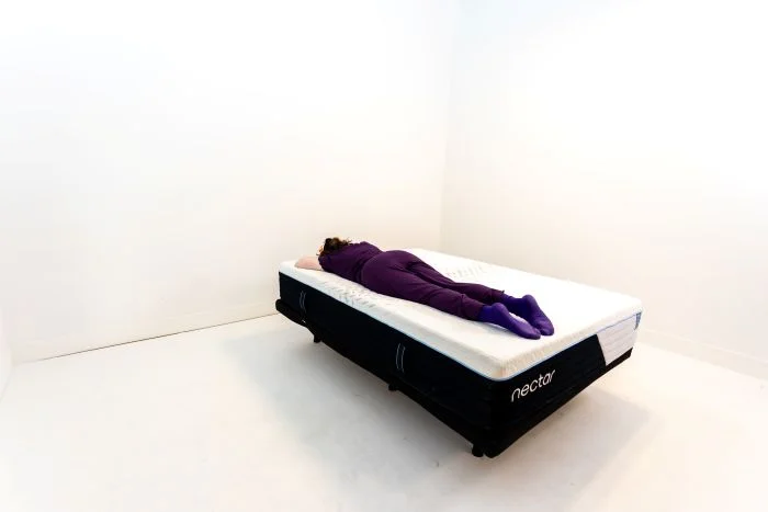 A woman lays on her stomach on the Nectar Classic Hybrid mattress.