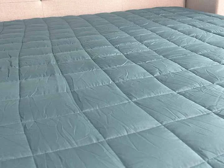 An image showing off the sewn through squares on the Ynm weighted blanket.