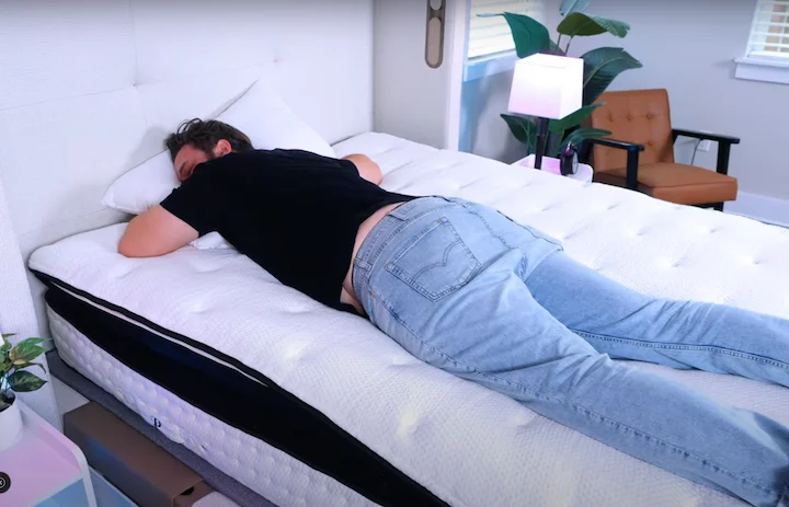 A man sleeps on his stomach on the PlushBeds Signature Bliss