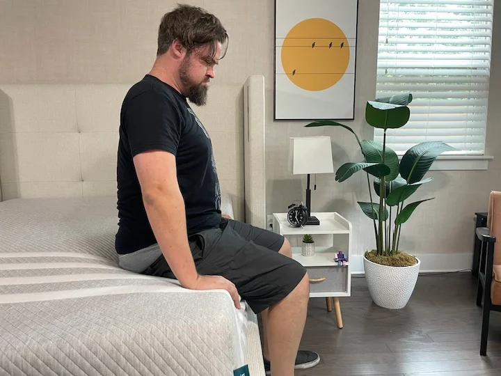 a man sits along the side of the Leesa Original Mattress