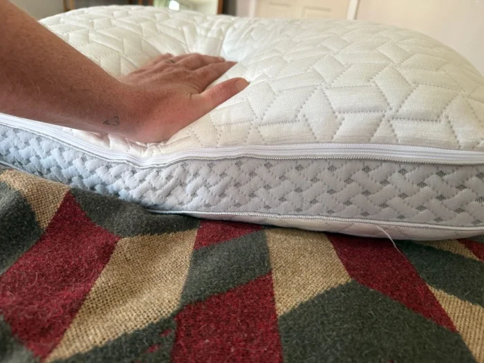 A person feels a Luxome LAYR Pillow.