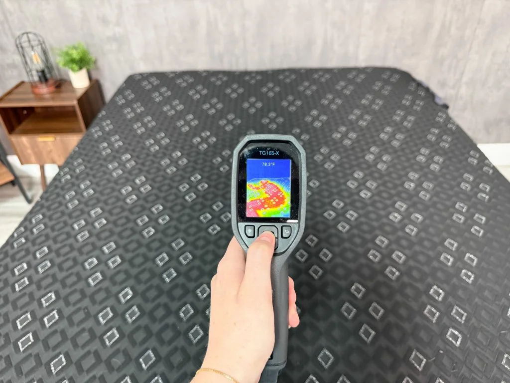 A thermal gun pointed at the surface of the Beautyrest Black Hybrid XCS, showing a thermal outline of our tester and measuring a temperature of 78.3 degrees
