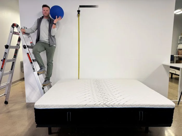 A man preps for the bounce test on the Nectar Classic Hybrid mattress.