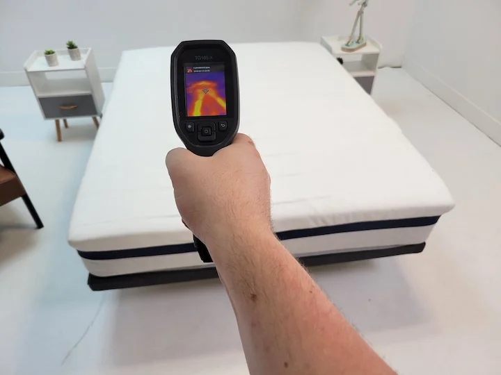 a man points a thermal gun at the Helix Midnight mattress